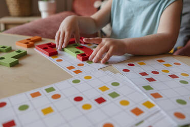 preschool age child playing educational wooden game at home. child's hand close up - KVBF00093