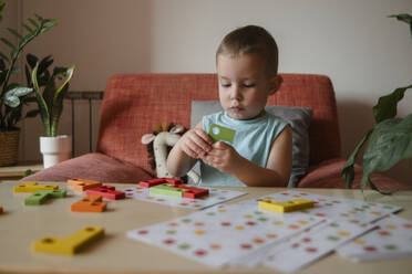 preschool age child playing educational wooden game at home - KVBF00094