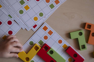 preschool age child playing educational wooden game at home.child's hand close up - KVBF00095