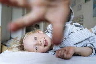 A 6 years old boy with blue eyes in blue pyjama is lying in the bed - NJAF00932