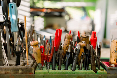 A collection of well-used shoemaking tools on a workstation in an Austrian shop, illustrating the shoemaker's craft. - ADSF54539