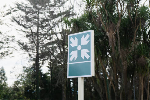 A tranquil outdoor scenery highlighting a sign with an air conditioning symbol, framed by lush trees. - ADSF54557