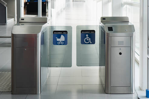 An image showcasing modern entry turnstiles with ticket readers at a building entrance, indicating accessibility options for individuals with disabilities. - ADSF54558
