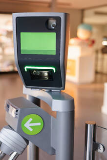 Close-up of an advanced ticket scanning machine at the entry point of a science museum, with an entry gate and arrow. - ADSF54585