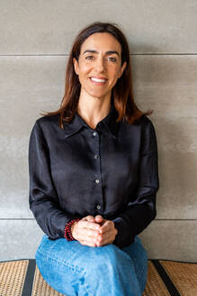 Smiling woman with long hair in a black shirt, looking at the camera, symbolizing modern female entrepreneurship. - ADSF54610