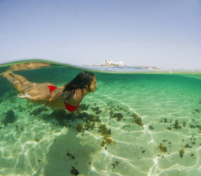 Frau genießt das klare Wasser in der Nähe eines Strandes auf Fuerteventura - ADSF54678