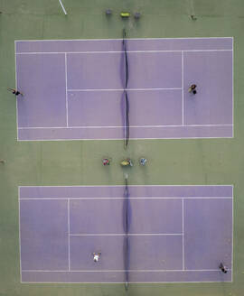 From above aerial shot of a tennis court with players engaged in a game, showcasing a top view angle. - ADSF54727