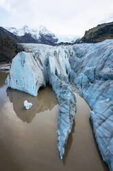 Nahaufnahme einer tiefblauen Gletscherspalte des Vatnajokull-Gletschers mit ihrer atemberaubenden Spiegelung im Schmelzwasser unter dem isländischen Himmel - ADSF54750