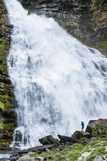 Ein einsamer Fotograf fängt die rohe Kraft eines gewaltigen Wasserfalls in der grünen Umarmung des Valle de Ordesa in Huesca ein - ADSF54761