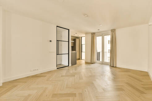 Ein Wohnzimmer mit Holzboden und einer Tür - ADSF54819
