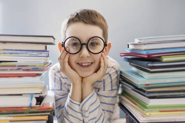 Ukraine, boy in eyeglasses sitting near books - ONAF00765