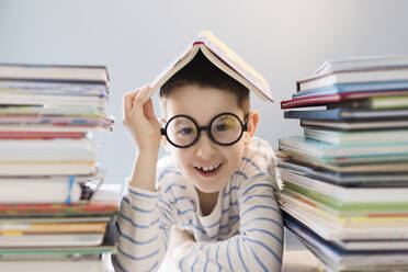 Ukraine, boy in eyeglasses sitting near books - ONAF00766