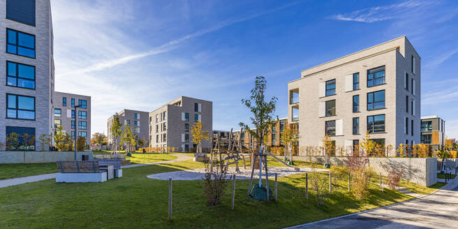 Deutschland, Baden-Württemberg, Leonberg, Spielplatz zwischen modernen Wohnhäusern im Neubaugebiet - WDF07556