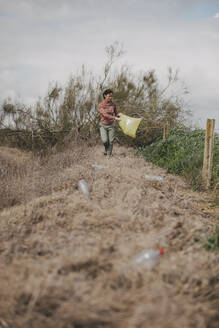 Pozoblanco, Andalusia, Spain - Woman collecting plastic bottles in the countryside. - DMGF01323