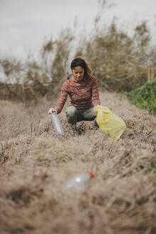 Pozoblanco, Andalusia, Spain - Woman collecting plastic bottles in the countryside. - DMGF01325