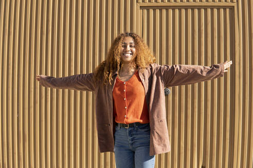 Curly haired black girl posing smiling and dancing in a brown jacket. Granada, Spain. - MGRF01137