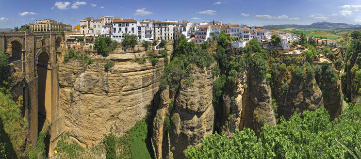 Luftaufnahme von Ronda, Andalusien, Spanien, mit schöner Architektur und historischen Steingebäuden, mit Blick auf den Panoramablick auf die Schlucht und den blauen Himmel. - AAEF28080