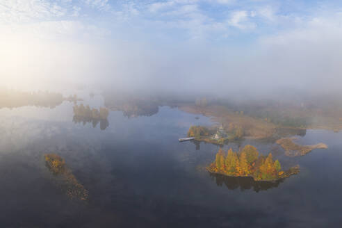 Aerial view of misty golden hour landscape over foggy forest, Karelia, Russia. - AAEF28198