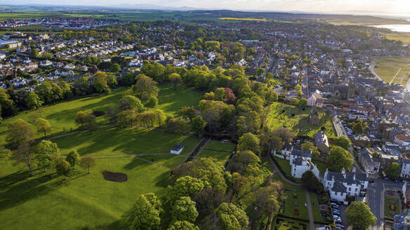 Aerial view of a beautiful coastal town with lush green spaces, tree-lined streets, and a scenic view of the coastline and sea, North Berwick, Scotland. - AAEF28464