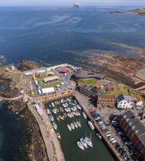 Aerial view of coastal town with colorful houses and boats during Fringe Festival, East Lothian, Scotland. - AAEF28473