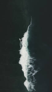 Aerial view of a surfer swimming in the ocean waves in Portugal. - AAEF28594