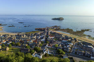 Aerial view of coastal town with beautiful blue ocean and scenic coastline, North Berwick, Scotland. - AAEF28685