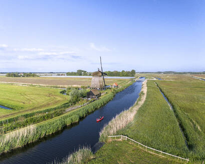 Aerial drone view of kayak and Dutch windmill near the city of Alkmaar, The Netherlands. - AAEF28719