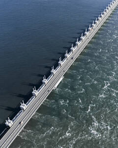 Aerial drone view of storm surge barrier Oosterscheldekering, bridge and water barrier, The Netherlands. - AAEF28732