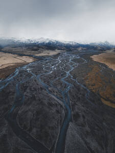 Aerial view of a braided river leading up to a mountain range near Vik, Iceland. - AAEF28765