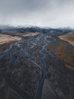 Aerial view of a braided river leading up to a mountain range near Vik, Iceland. - AAEF28765