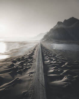 Aerial view of a person standing on the access road to Stokksnes at sunset, Iceland. - AAEF28772