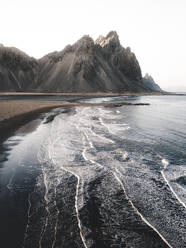 Aerial view of waves crashing onto the beach in front of Vestrahorn mountain, Stokksnes, Iceland. - AAEF28773