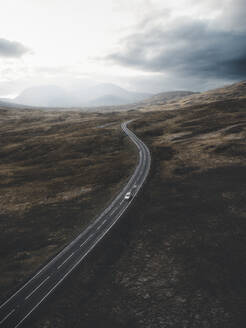 Aerial view of a car cruising through the Scottish highlands near Glencoe, Scotland. - AAEF28791