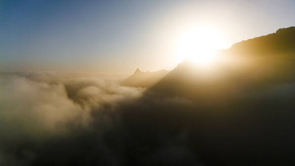 Drohnenaufnahme der Silhouette von Berggipfeln bei Sonnenaufgang, bedeckt von Wolken, Insel Santo Antao, Kap Verde. - AAEF29127