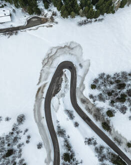 Luftaufnahme des Monte Boldone und der kurvenreichen Straße durch die verschneiten Alpen, Trentino, Italien. - AAEF29214