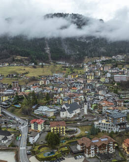 Luftaufnahme des Dorfes Molveno mit nebligen Dolomiten im Hintergrund, Molveno, Italien. - AAEF29245