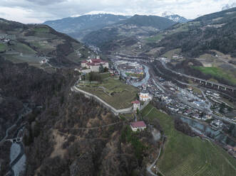 Aerial view of Klausen town with Sabiona Monastery and vineyards, South Tyrol, Italy. - AAEF29320