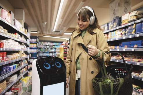 Intelligenter Roboter interagiert mit lächelnder Frau im Supermarkt - ALKF01154