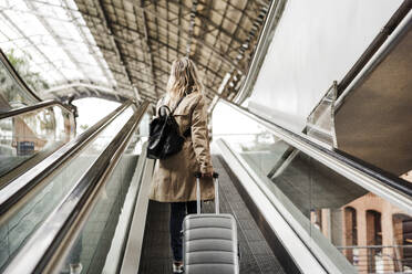 Frau mit Gepäck und Rolltreppe auf dem Bahnhof - EBBF08862