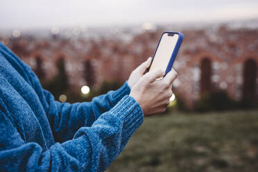 Woman using smart phone at sunset - EBBF08893