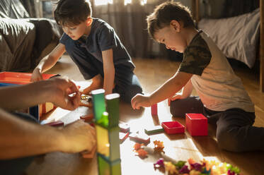 Kinder spielen zu Hause mit Blockspielzeug - ANAF02828