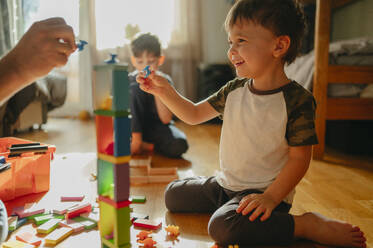 Smiling boy playing games with father at home - ANAF02832