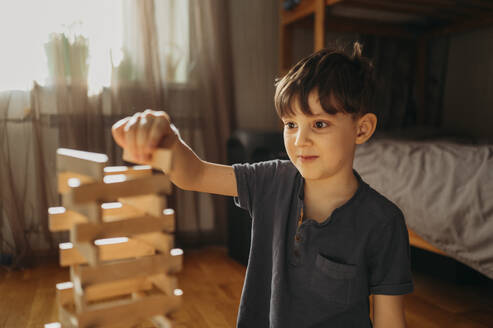 Junge spielt zu Hause ein Spiel zum Entfernen von Blöcken - ANAF02840