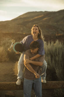 Couple enjoying a nice time together with a skateboard. Tenerife, Canary Islands, Spain. - ACPF01577