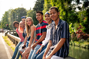 Group of multiethnic teenagers spending time outdoor and having fun. Concept about generation z, lifestyle and friendship - DMDF11439