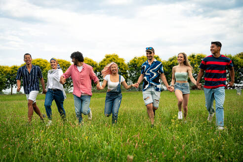 Eine Gruppe multiethnischer Jugendlicher verbringt ihre Zeit bei einem Picknick im Park. Konzept über die Generation Z, Lebensstil und Freundschaft - DMDF11477