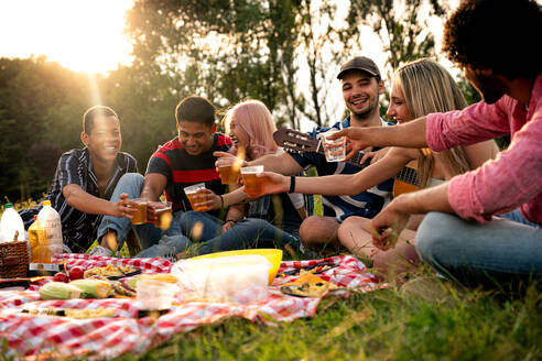 Eine Gruppe multiethnischer Jugendlicher verbringt ihre Zeit bei einem Picknick im Park. Konzept über die Generation Z, Lebensstil und Freundschaft - DMDF11517