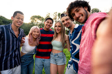Eine Gruppe multiethnischer Jugendlicher verbringt ihre Zeit bei einem Picknick im Park. Konzept über die Generation Z, Lebensstil und Freundschaft - DMDF11540