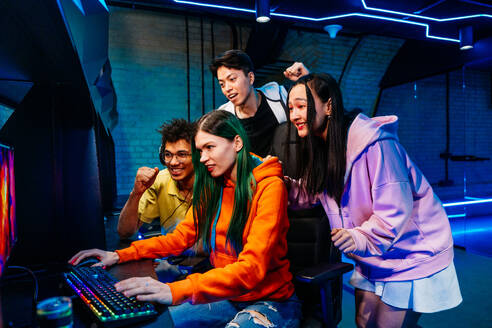 Multiethnic group of young friends playing videogames - Team of professional esport gamers playing in competitive video games on a cyber Games Tournament - DMDF11635