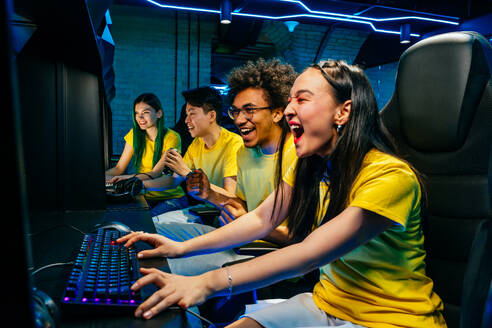 Multiethnische Gruppe junger Freunde, die Videospiele spielen - Team professioneller esport-Spieler, die in wettbewerbsfähigen Videospielen an einem Cyber-Games-Turnier teilnehmen - DMDF11671